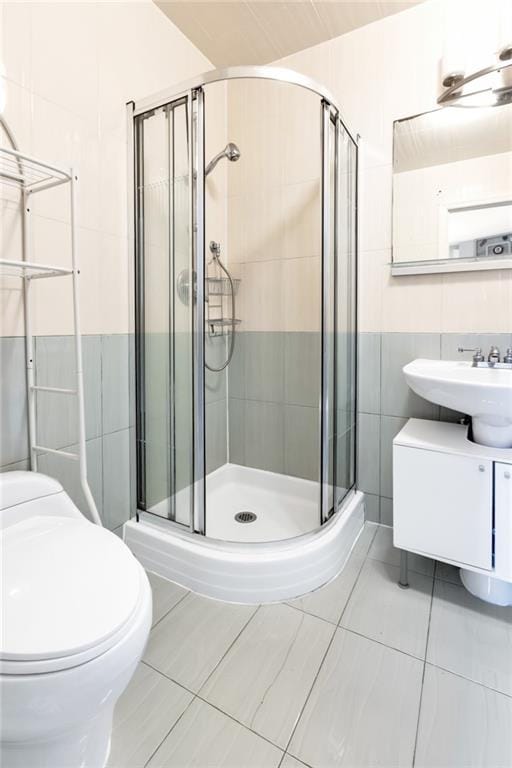 135 28th Ave Unit 2A, Brooklyn, NY 11214 - full bathroom featuring tile walls, a stall shower, vanity, and tile patterned floors