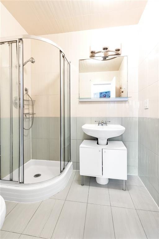 135 28th Ave Unit 2A, Brooklyn, NY 11214 - full bath with tile walls, a stall shower, vanity, and tile patterned floors