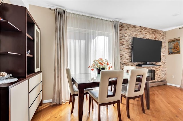 135 28th Ave Unit 2A, Brooklyn, NY 11214 - dining room featuring light wood-style flooring and a baseboard radiator