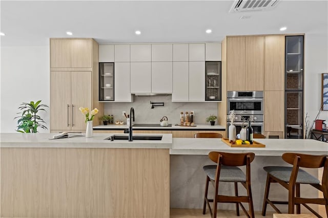 320 10th St, Brooklyn, NY 11215 - kitchen featuring modern cabinets, a kitchen bar, double oven, recessed lighting, and decorative backsplash