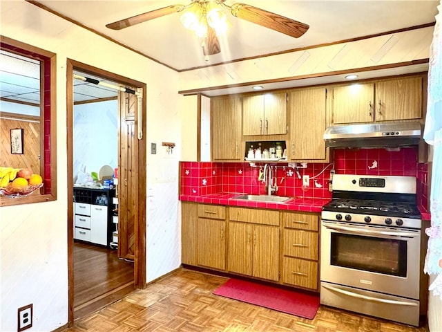 3516 Fillmore Ave, Brooklyn, NY 11234 - kitchen featuring gas stove, under cabinet range hood, tile counters, and tasteful backsplash