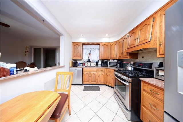 1296 E 54th St, Brooklyn, NY 11234 - kitchen featuring stainless steel appliances, light tile patterned floors, light countertops, backsplash, and ventilation hood