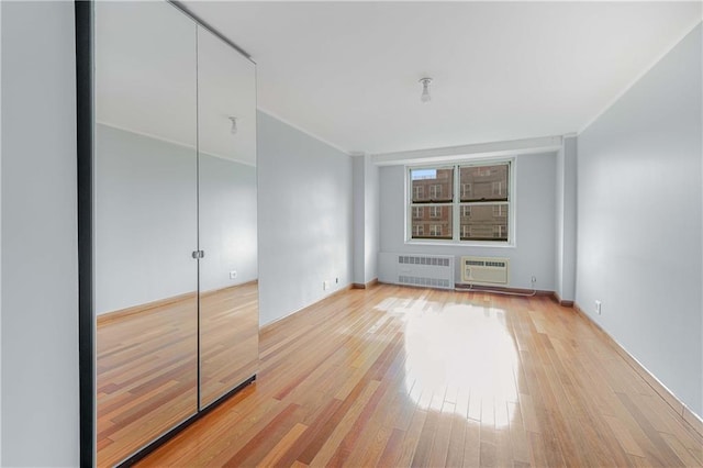 35 Seacoast Ter Unit 8A, Brooklyn, NY 11235 - unfurnished bedroom featuring radiator, light wood-type flooring, and a wall unit AC