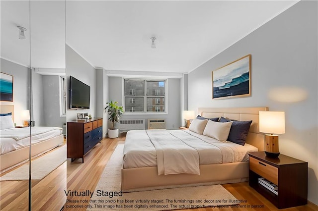 35 Seacoast Ter Unit 8A, Brooklyn, NY 11235 - bedroom featuring radiator heating unit, light wood-type flooring, crown molding, and a wall mounted AC