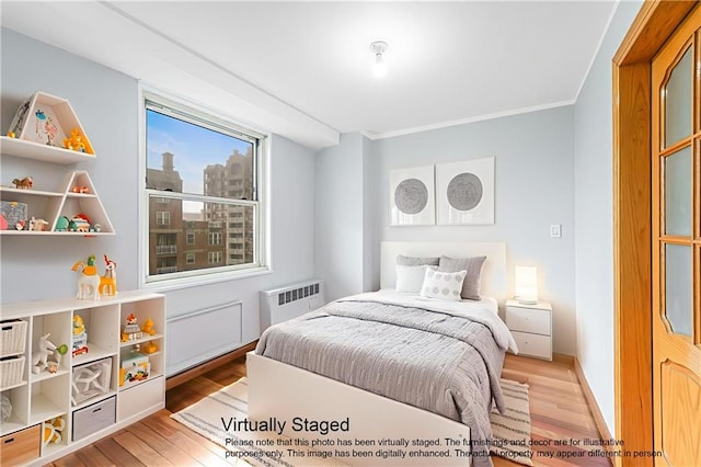 35 Seacoast Ter Unit 8A, Brooklyn, NY 11235 - bedroom with radiator heating unit, light wood finished floors, and ornamental molding