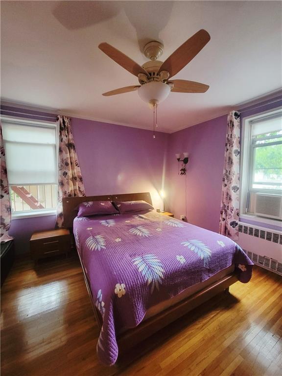 388 Avenue S Unit 2C, Brooklyn, NY 11223 - bedroom featuring radiator heating unit, hardwood / wood-style floors, a ceiling fan, and cooling unit