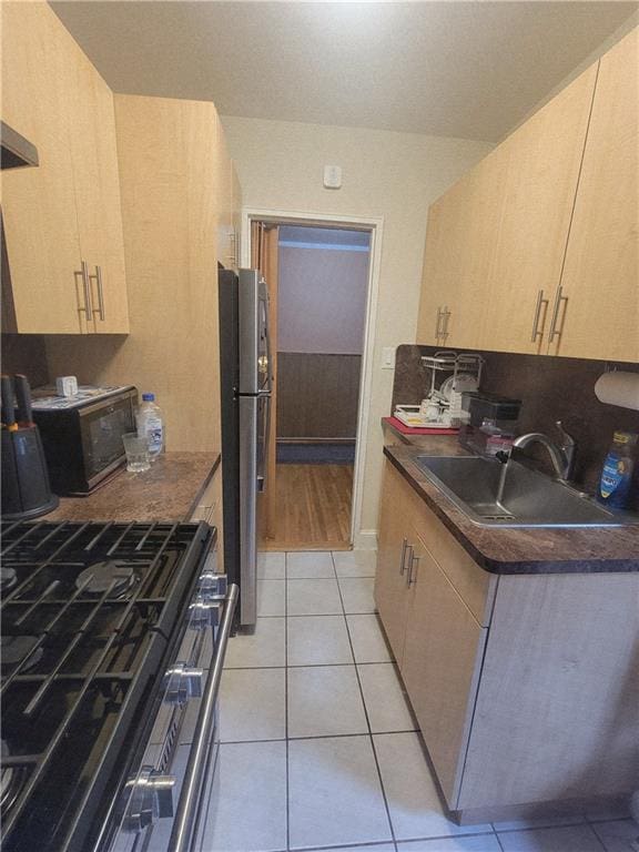 388 Avenue S Unit 2C, Brooklyn, NY 11223 - kitchen featuring range with gas stovetop, freestanding refrigerator, dark countertops, and light tile patterned flooring