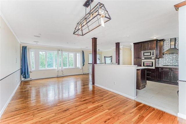 161 Ravenhurst Ave, Staten Island, NY 10310 - kitchen with stainless steel appliances, wall chimney range hood, light wood finished floors, dark brown cabinetry, and crown molding