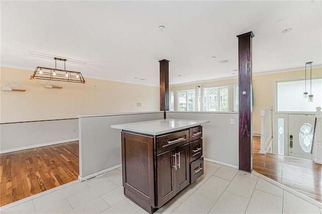 161 Ravenhurst Ave, Staten Island, NY 10310 - kitchen with dark brown cabinets, hanging light fixtures, light countertops, a kitchen island, and crown molding