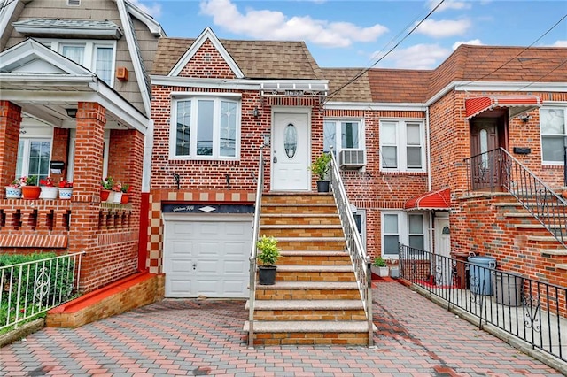 1650 E 48th St, Brooklyn, NY 11234 - view of property featuring brick siding, an attached garage, a shingled roof, cooling unit, and driveway