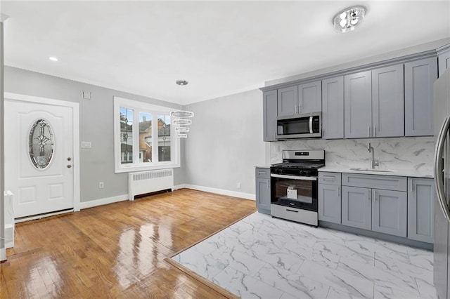 1650 E 48th St, Brooklyn, NY 11234 - kitchen featuring radiator, stainless steel appliances, gray cabinets, decorative backsplash, and light countertops