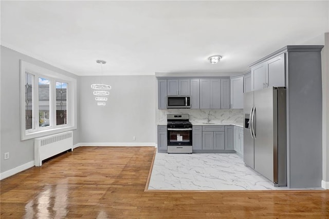 1650 E 48th St, Brooklyn, NY 11234 - kitchen featuring stainless steel appliances, radiator, gray cabinets, decorative backsplash, and light countertops