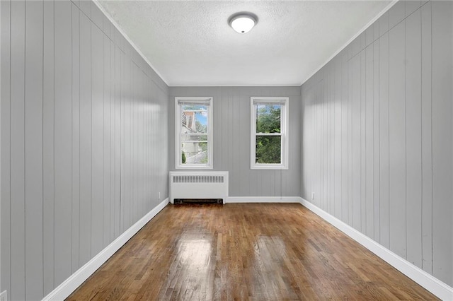 1650 E 48th St, Brooklyn, NY 11234 - spare room featuring radiator, wood finished floors, a textured ceiling, and ornamental molding