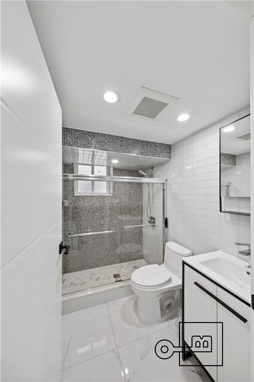 1168 E 12th St, Brooklyn, NY 11230 - full bath featuring vanity, a stall shower, tile walls, recessed lighting, and tile patterned flooring