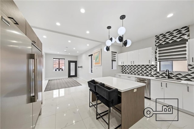 1168 E 12th St, Brooklyn, NY 11230 - kitchen featuring stainless steel appliances, light countertops, backsplash, white cabinetry, and recessed lighting