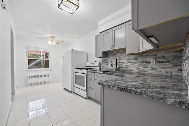 2426 Bragg St, Brooklyn, NY 11235 - kitchen with white appliances, radiator heating unit, gray cabinets, and backsplash