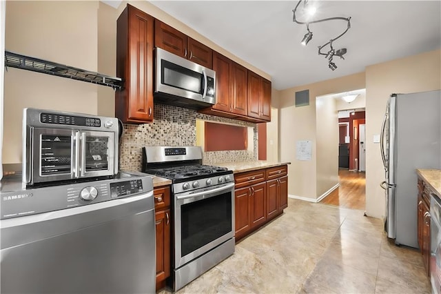 2426 Bragg St, Brooklyn, NY 11235 - kitchen featuring appliances with stainless steel finishes, decorative backsplash, and washer / clothes dryer