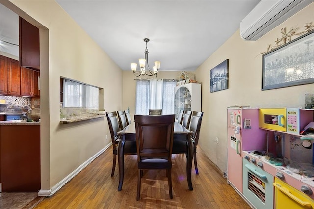 2426 Bragg St, Brooklyn, NY 11235 - dining space with a wall mounted air conditioner, a chandelier, and hardwood / wood-style floors