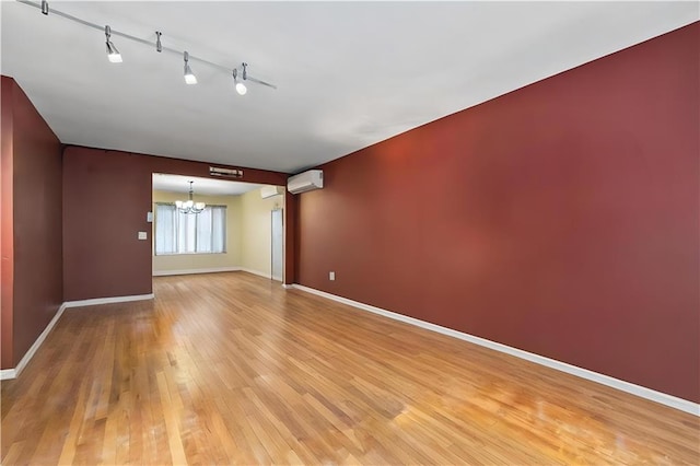 2426 Bragg St, Brooklyn, NY 11235 - empty room featuring a chandelier, a wall mounted AC, and light wood-style flooring