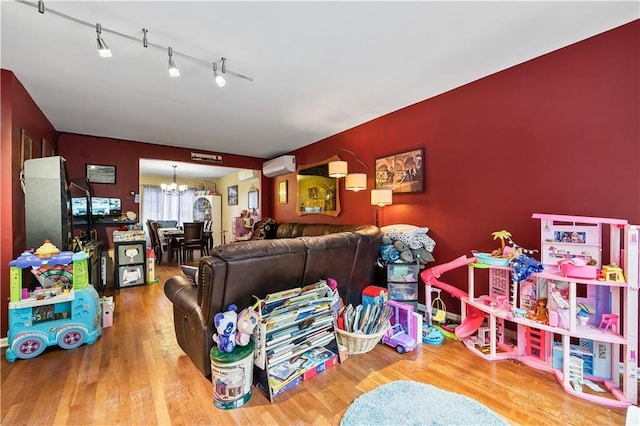 2426 Bragg St, Brooklyn, NY 11235 - living room featuring a wall mounted AC, a chandelier, and wood finished floors