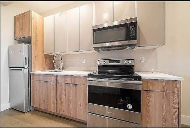 1281 Nostrand Ave, Brooklyn, NY 11226 - kitchen with appliances with stainless steel finishes, light countertops, light wood-style floors, and modern cabinets