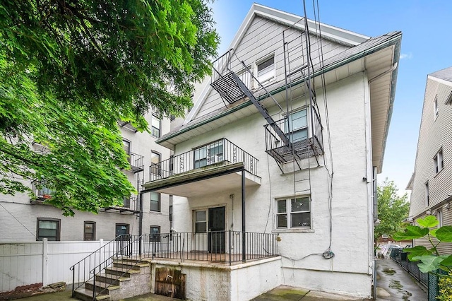 8309 19th Ave, Brooklyn, NY 11214 - rear view of property with a balcony and stucco siding