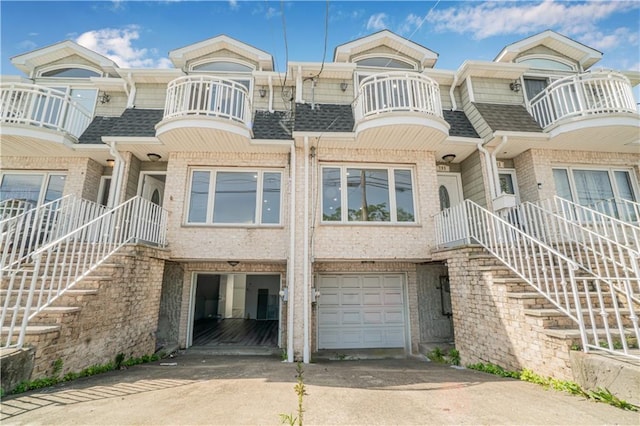 795 Father Capodanno Blvd, Staten Island, NY 10305 - view of front of house with brick siding, a shingled roof, driveway, and a garage