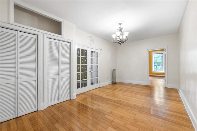 317 Pennsylvania Ave, Brooklyn, NY 11207 - unfurnished dining area featuring a chandelier, light wood-type flooring, radiator heating unit, and french doors