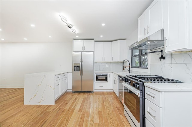 590 E 83rd St, Brooklyn, NY 11236 - kitchen featuring stainless steel appliances, under cabinet range hood, a peninsula, decorative backsplash, and light wood-style flooring