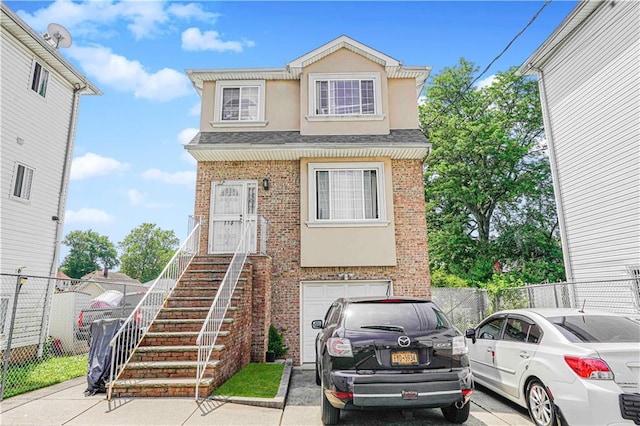 134 S Ave, Staten Island, NY 10303 - view of front of house featuring brick siding, a garage, stucco siding, and roof with shingles
