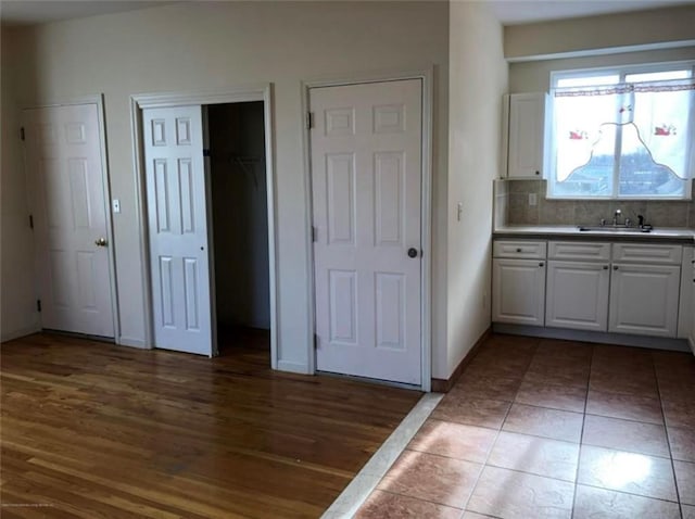 134 S Ave, Staten Island, NY 10303 - kitchen featuring white cabinets, decorative backsplash, and wood finished floors