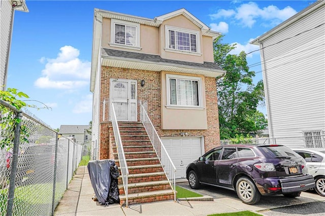 134 S Ave, Staten Island, NY 10303 - townhome / multi-family property featuring brick siding, an attached garage, stucco siding, a shingled roof, and driveway