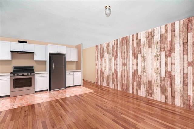 134 S Ave, Staten Island, NY 10303 - kitchen featuring freestanding refrigerator, stainless steel stove, light countertops, light wood-style flooring, and white cabinets
