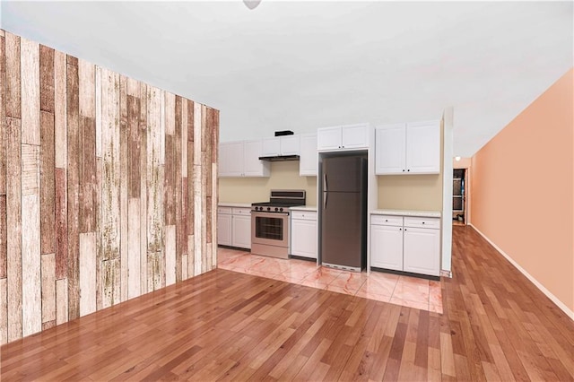 134 S Ave, Staten Island, NY 10303 - kitchen featuring stainless steel stove, freestanding refrigerator, light wood-type flooring, light countertops, and white cabinetry