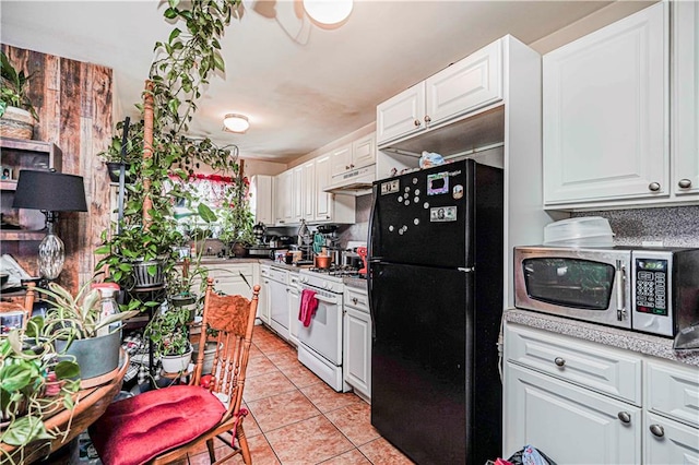 134 S Ave, Staten Island, NY 10303 - kitchen featuring freestanding refrigerator, stainless steel microwave, white gas stove, under cabinet range hood, and white cabinetry
