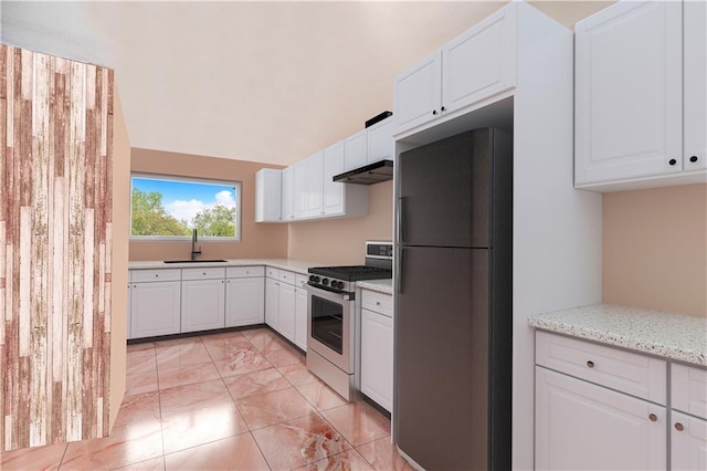 134 S Ave, Staten Island, NY 10303 - kitchen with freestanding refrigerator, gas stove, under cabinet range hood, white cabinets, and light marble finish floors
