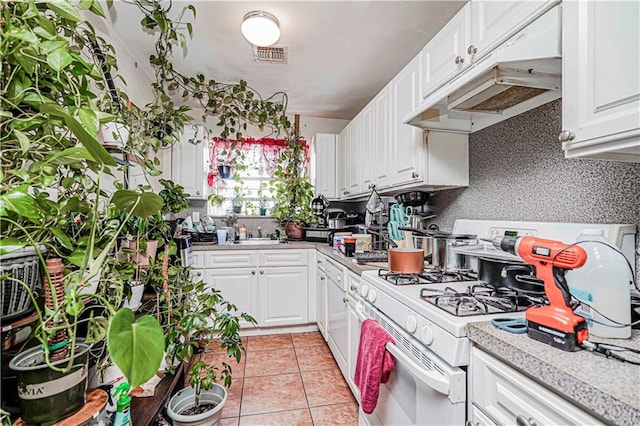 134 S Ave, Staten Island, NY 10303 - kitchen featuring white gas range, light countertops, under cabinet range hood, white cabinetry, and light tile patterned flooring