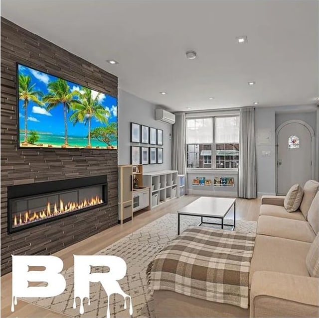 2507 E 23rd St, Brooklyn, NY 11235 - living area featuring a wall mounted AC, a glass covered fireplace, wood finished floors, and recessed lighting