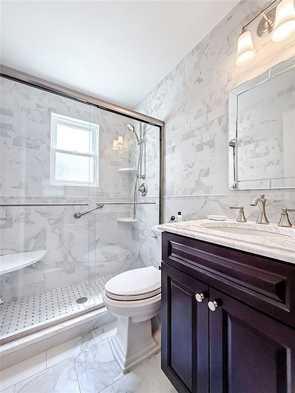 143 Getz Ave, Staten Island, NY 10312 - full bath featuring vanity, tile walls, a marble finish shower, and marble look tiles