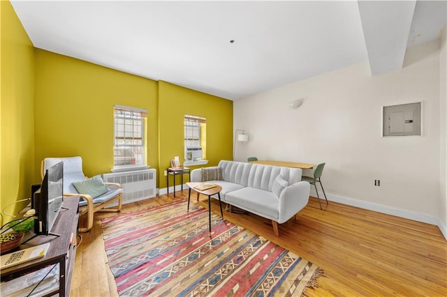1240 Bedford Ave Unit 1H, Brooklyn, NY 11216 - living room with radiator heating unit, electric panel, light wood-style floors, and cooling unit