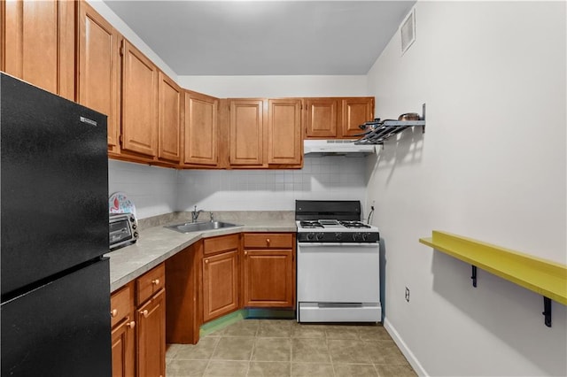 1240 Bedford Ave Unit 1H, Brooklyn, NY 11216 - kitchen featuring freestanding refrigerator, gas range gas stove, under cabinet range hood, and decorative backsplash