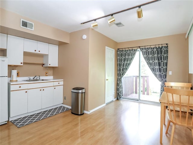 5 Greaves Ave, Staten Island, NY 10308 - kitchen with light wood finished floors, white cabinets, light countertops, track lighting, and freestanding refrigerator