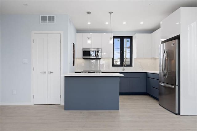 33A Keen Ct, Brooklyn, NY 11229 - kitchen featuring stainless steel appliances, modern cabinets, light wood-style floors, white cabinets, and recessed lighting