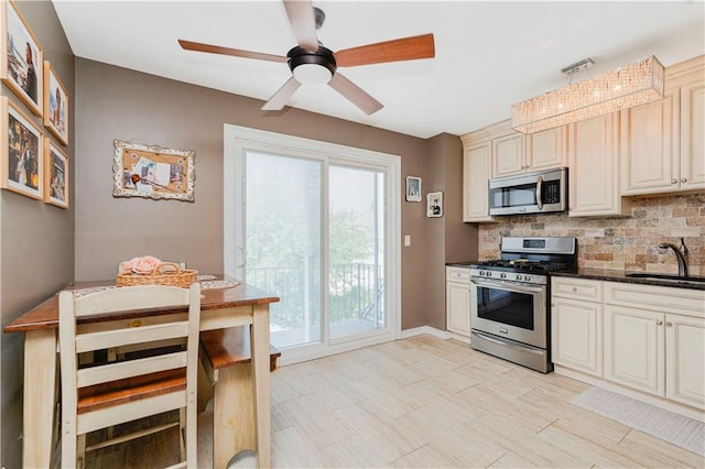 172 Rosedale Ave, Staten Island, NY 10312 - kitchen featuring stainless steel appliances, decorative backsplash, a ceiling fan, cream cabinets, and dark stone countertops
