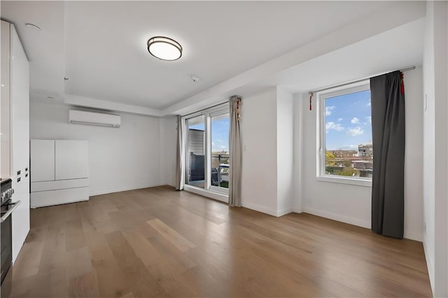 623 H Ave Unit 7C, New York, NY 11230 - spare room with light wood-style flooring, healthy amount of natural light, and a wall unit AC