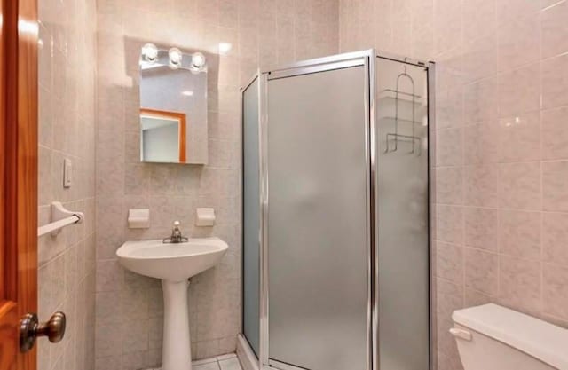 4817 Bedford Ave Unit 3A, Brooklyn, NY 11235 - full bathroom with tile walls, a stall shower, and tile patterned floors