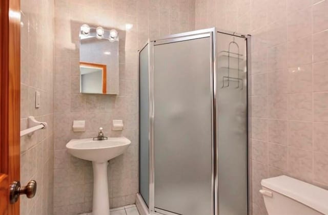 4817 Bedford Ave Unit 3A, Brooklyn, NY 11235 - full bath featuring tile walls, a shower stall, and tile patterned flooring