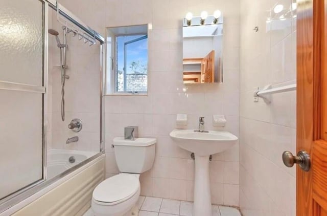 4817 Bedford Ave Unit 3A, Brooklyn, NY 11235 - bathroom featuring combined bath / shower with glass door, tile walls, and tile patterned flooring