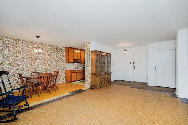 1935 Shore Pkwy Unit 8E, Brooklyn, NY 11214 - kitchen featuring wallpapered walls, brown cabinetry, pendant lighting, a chandelier, and light countertops