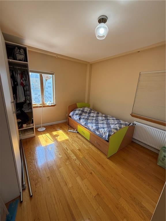 2964 Brighton 6th St Unit 4B, Brooklyn, NY 11235 - bedroom featuring radiator heating unit and wood finished floors